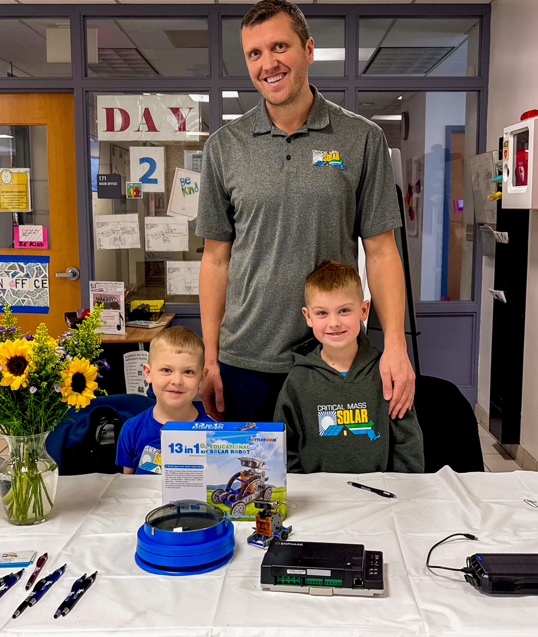 Freddy Petkus with his children at a Critical Mass Solar education display, demonstrating the company's community commitment